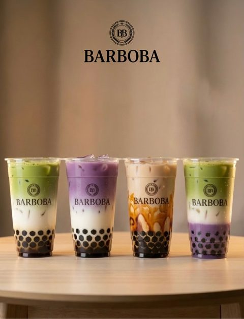 Four Barboba cups, matcha, taro, classic and taro matcha, on a wooden table under the Barboba crest